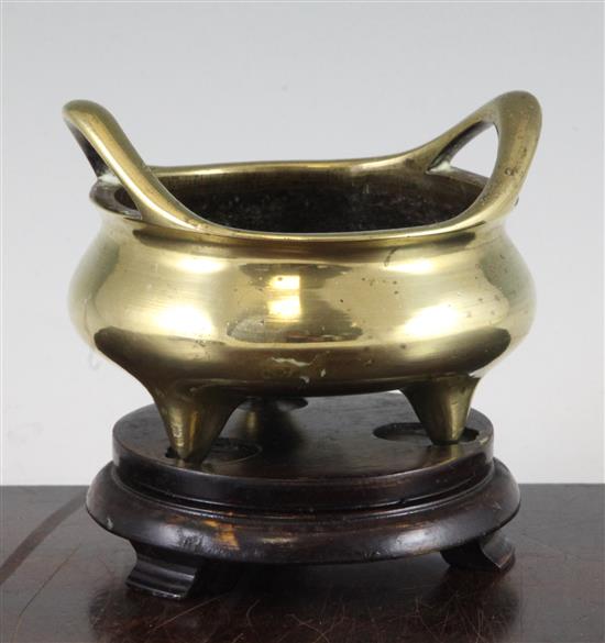 A Chinese bronze tripod censer, six character Xuande mark, 19th century, 11.5cm, wood stand